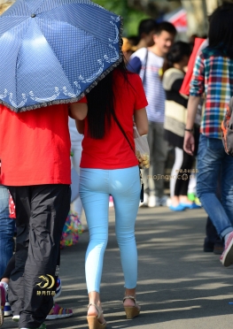 遮阳伞下的美丽身影 街拍紧身裤美女
